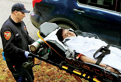 An Alton, Ill., Fire Department paramedic, left, wheels 17-year-old William Michael Bryars, handcuffed to a stretcher, to a waiting ambulance Friday morning January 20, 2017, after he crashed the Nissan Altima he was driving into a untility pole, ending a high speed chase through Alton by U.S. Marshals and Alton Police. (photo by John Badman/The Telegraph)